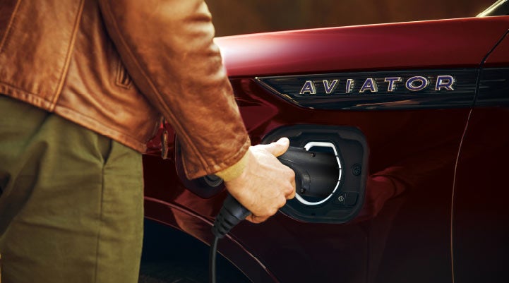 A hand is shown plugging in the charger into the charging port of a 2021 Lincoln Aviator | Ted Russell Lincoln in Knoxville TN