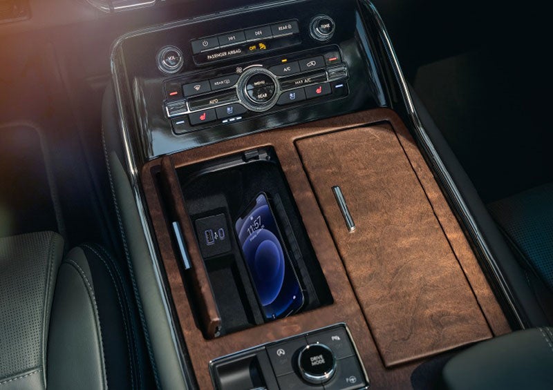 A smartphone is charging on the wireless charging pad* in the front center console cubby. | Ted Russell Lincoln in Knoxville TN
