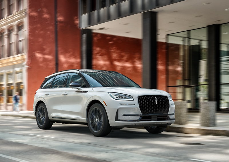 The 2024 Lincoln Corsair® SUV with the Jet Appearance Package and a Pristine White exterior is parked on a city street. | Ted Russell Lincoln in Knoxville TN